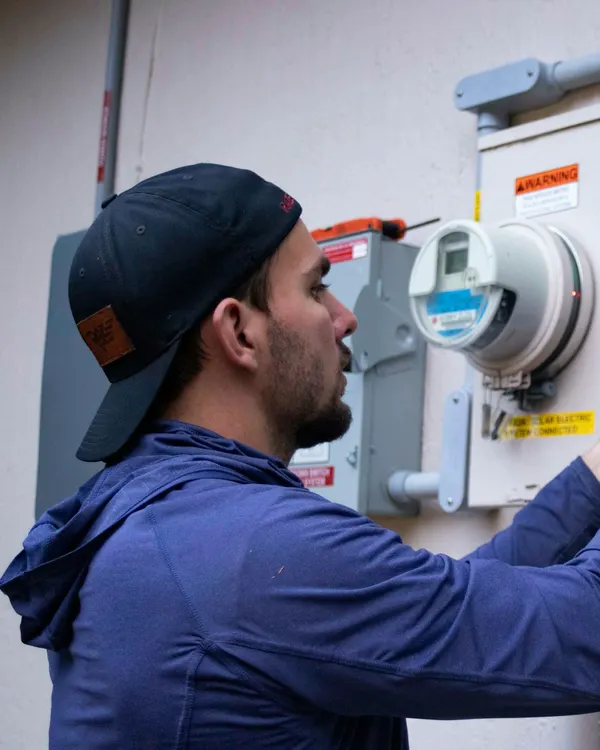 Electrician working on an outdoor electrical panel